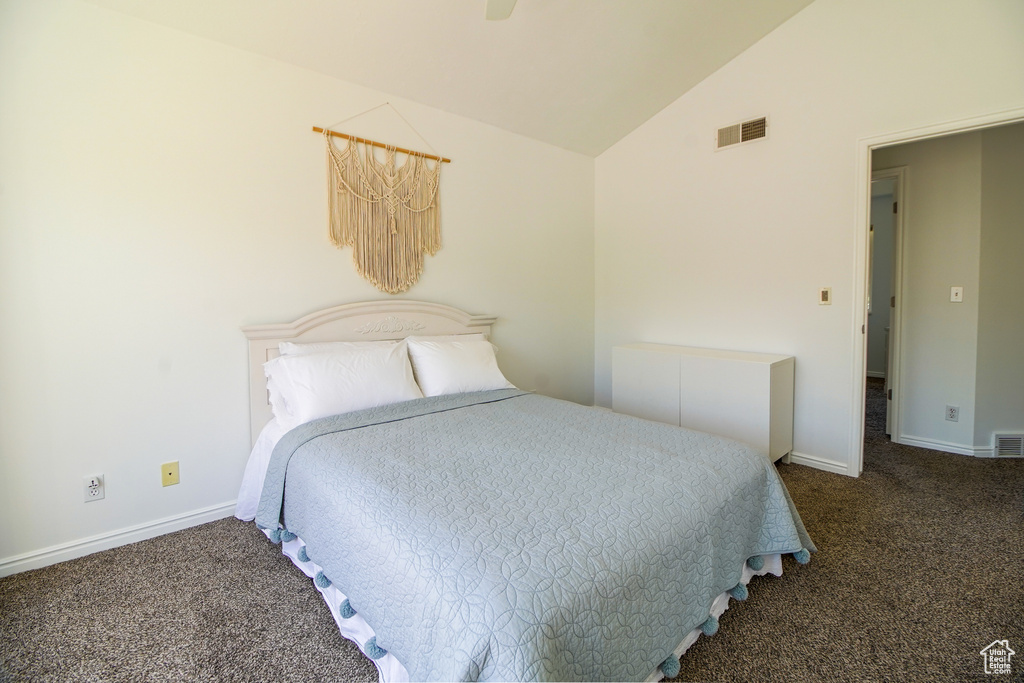 Carpeted bedroom featuring vaulted ceiling and baseboards