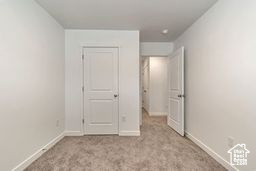 Unfurnished bedroom featuring baseboards and carpet