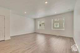 Empty room with wood finished floors and recessed lighting