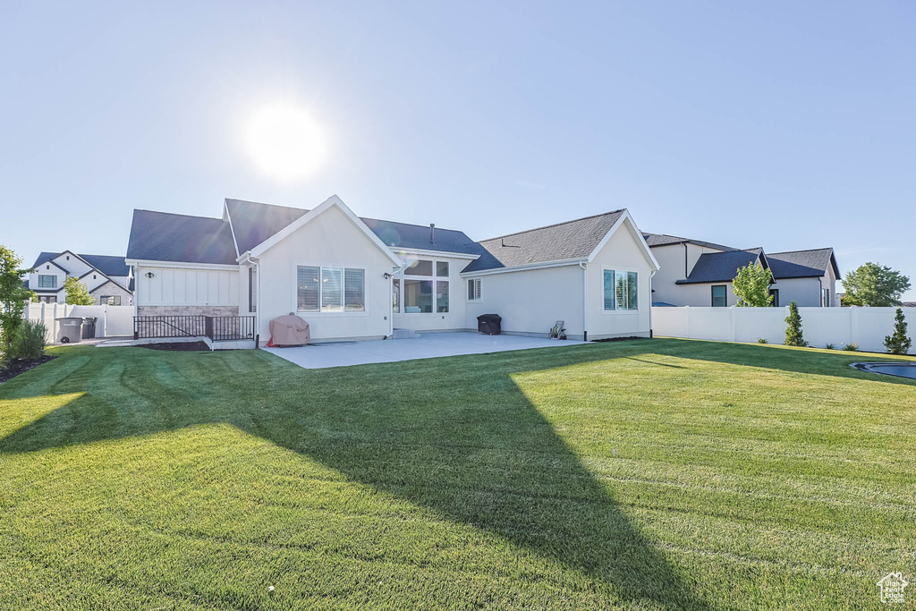 Rear view of property with a patio and board and batten siding