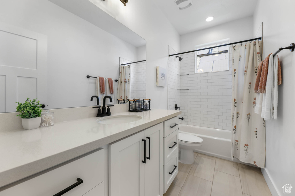 Full bath featuring vanity, shower / bath combo, and tile patterned floors
