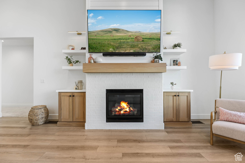 Living room featuring a brick fireplace and light wood finished floors