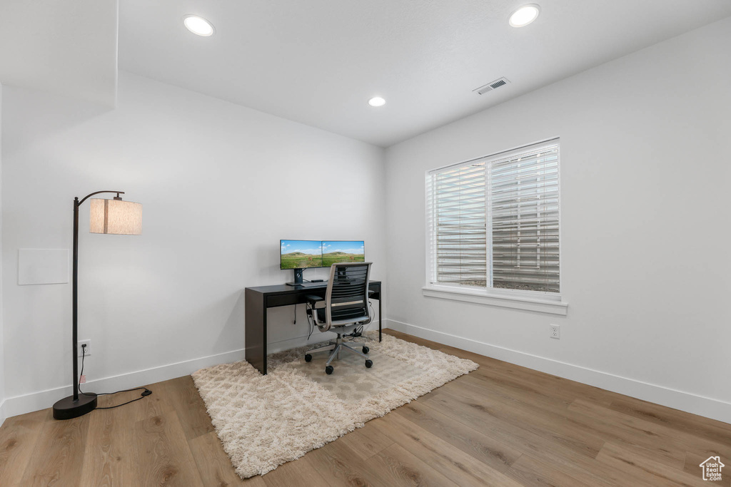Office space with wood finished floors and recessed lighting