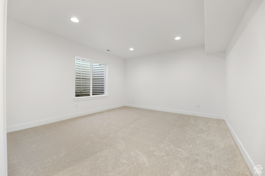 Empty room featuring light colored carpet and recessed lighting