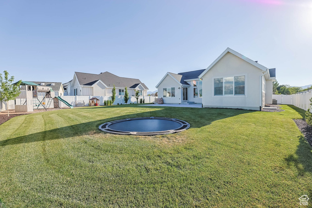 Fenced backyard with a playground and a residential view