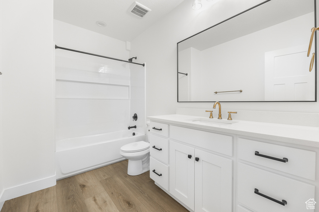Bathroom featuring wood finished floors, vanity, and bathing tub / shower combination