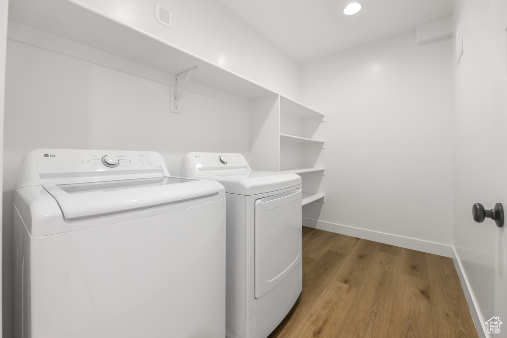 Laundry room featuring washer and dryer, light wood-style floors, and recessed lighting