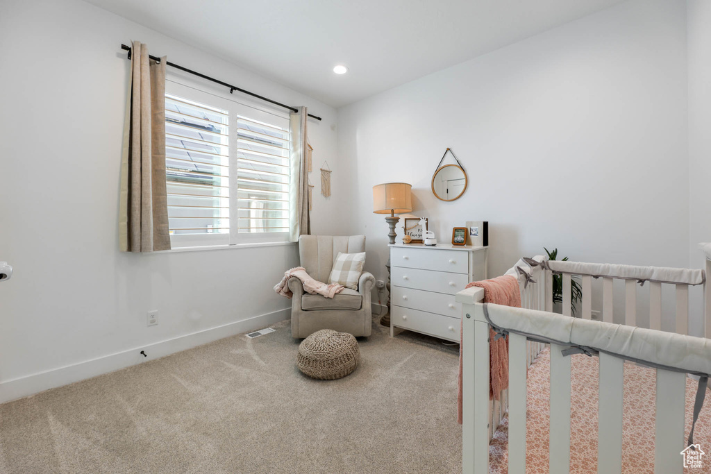 Carpeted bedroom with a nursery area and recessed lighting