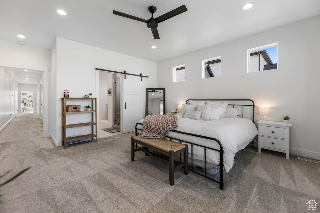 Carpeted bedroom with a barn door, recessed lighting, ensuite bathroom, and ceiling fan