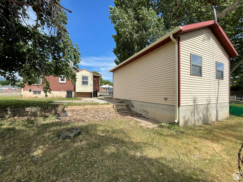 View of side of property with a lawn