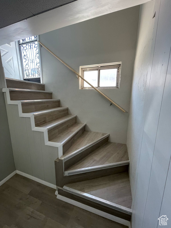Staircase with wood finished floors and baseboards