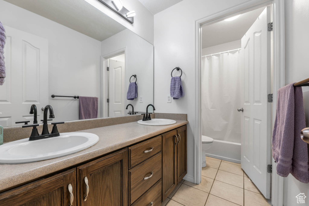Bathroom with double vanity, tile patterned floors, and shower / bath combination with curtain