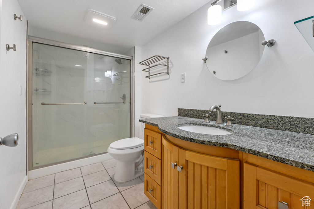 Bathroom with vanity, a stall shower, and tile patterned flooring