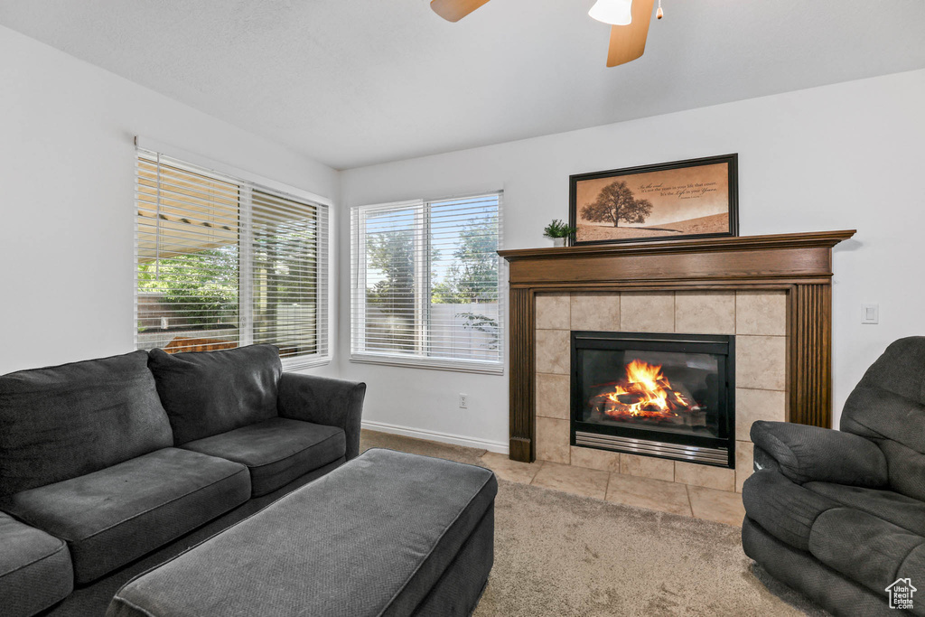 Living room with a fireplace, ceiling fan, and carpet flooring