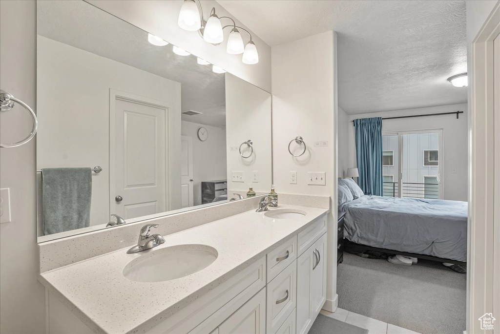 Ensuite bathroom featuring double vanity and tile patterned floors