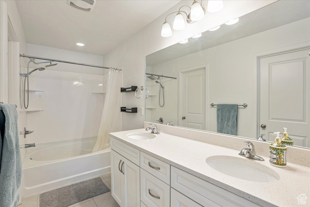 Bathroom featuring tile patterned floors, shower / bath combo, and double vanity