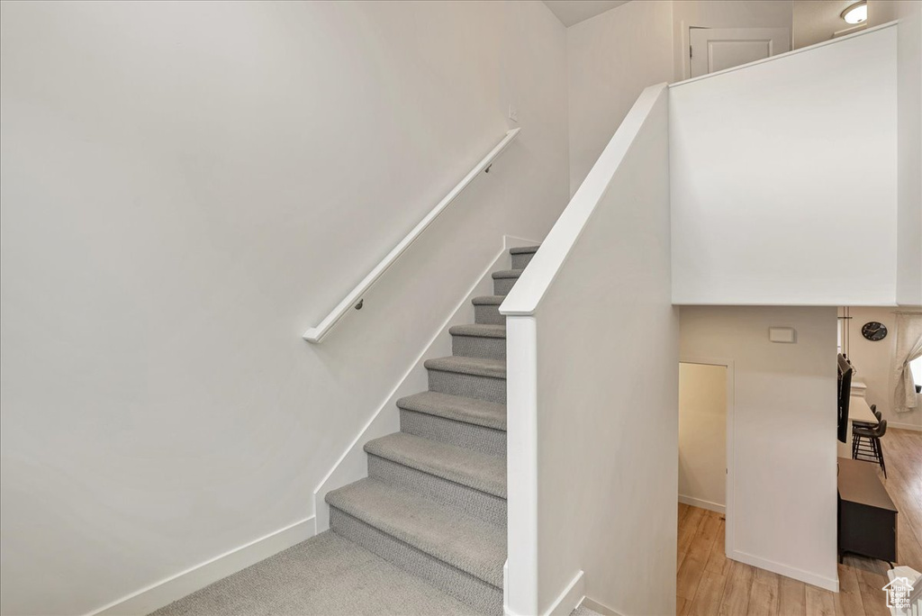 Staircase with wood finished floors and baseboards