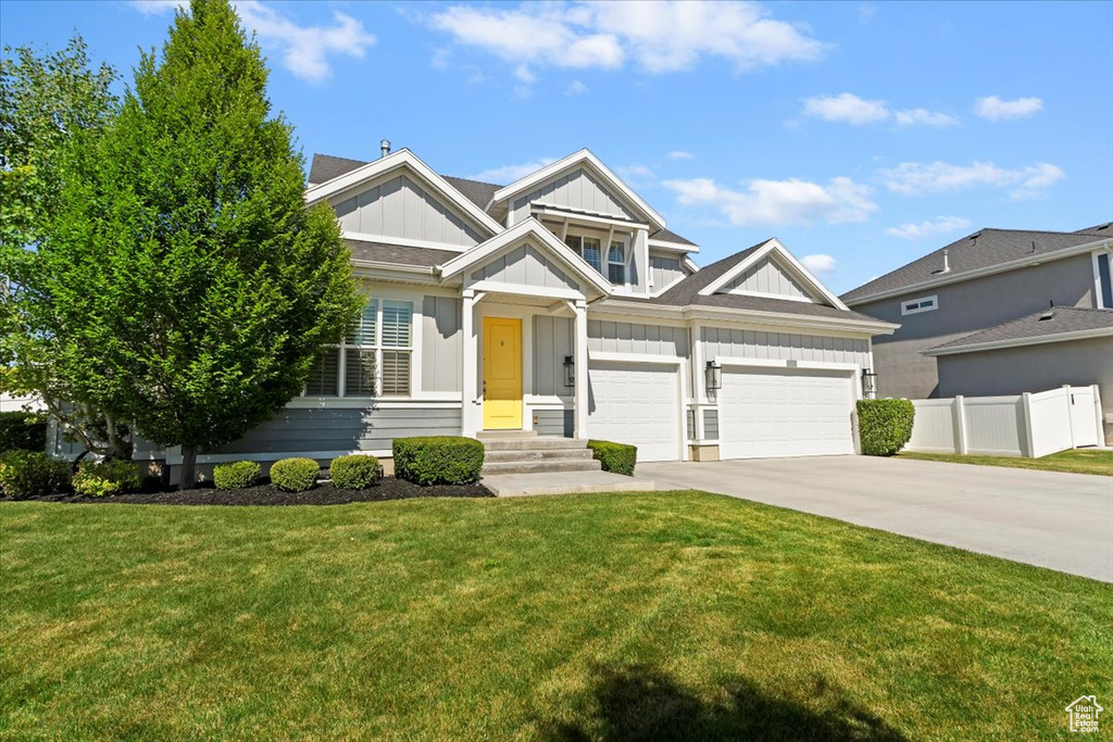 View of front of house with board and batten siding, concrete driveway, and a garage