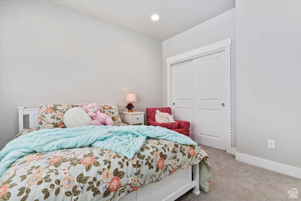 Bedroom featuring light colored carpet, a closet, and recessed lighting