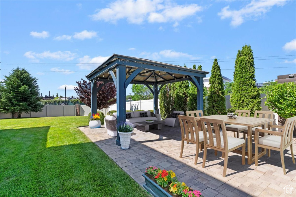 Fenced backyard featuring a gazebo, an outdoor hangout area, a patio, and outdoor dining area
