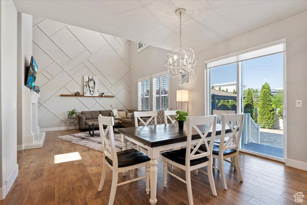 Dining space with a chandelier and wood-type flooring