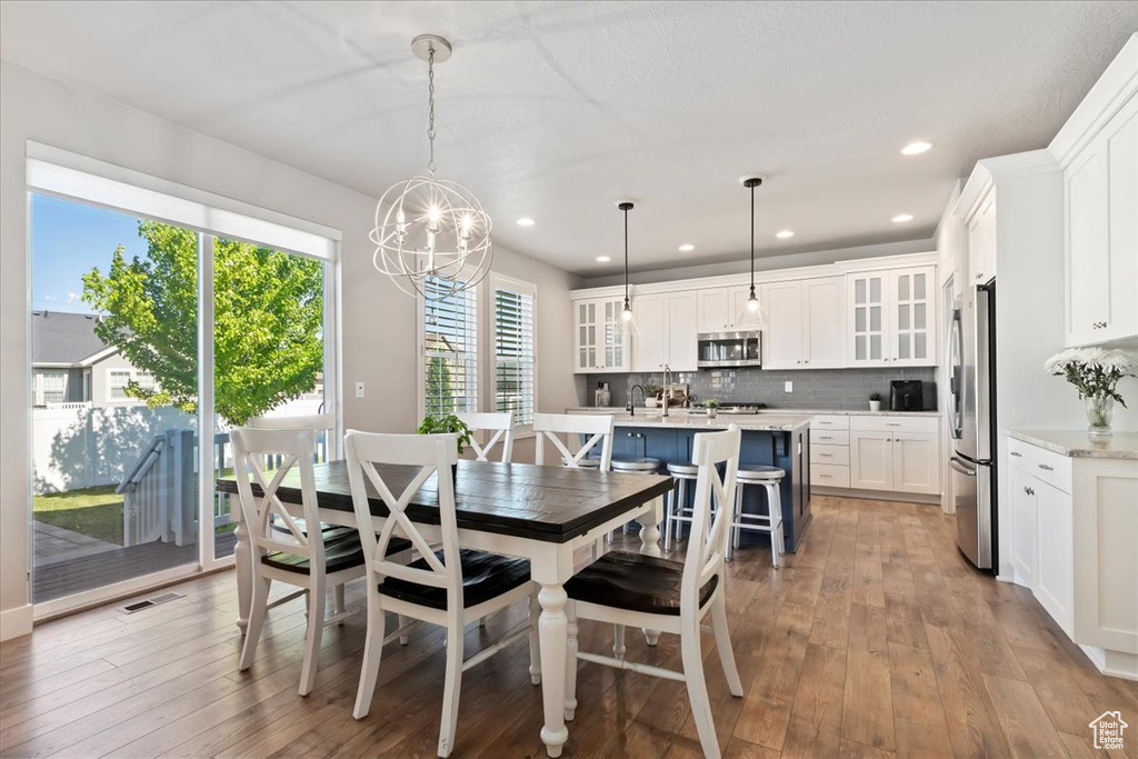 Dining room featuring a chandelier, hardwood / wood-style flooring, and recessed lighting