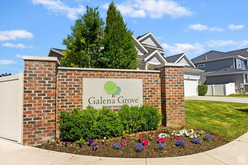 Community sign featuring an attached garage and driveway