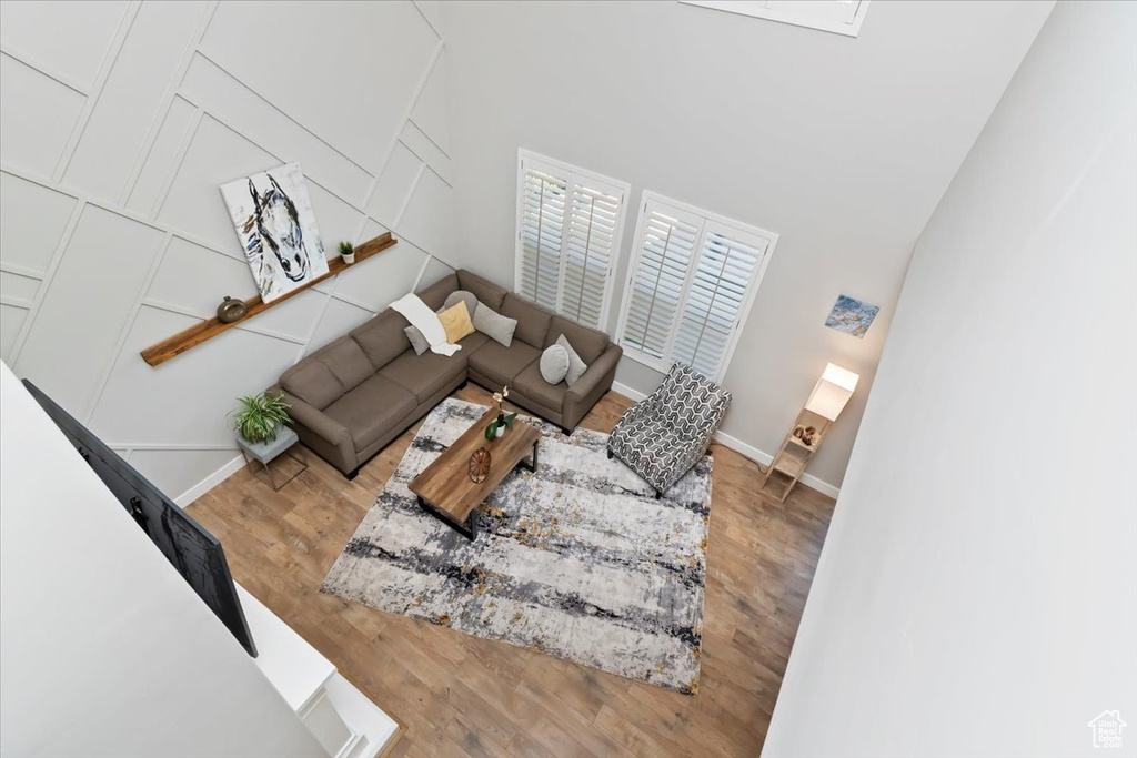 Living area featuring wood finished floors and a towering ceiling