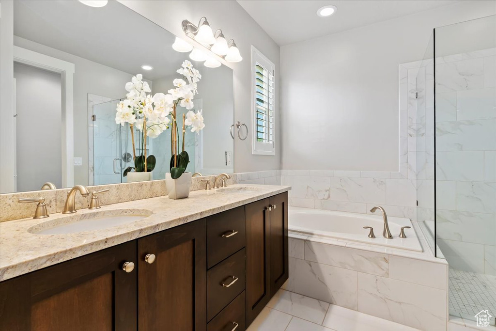 Bathroom with a garden tub, a shower stall, double vanity, and tile patterned floors