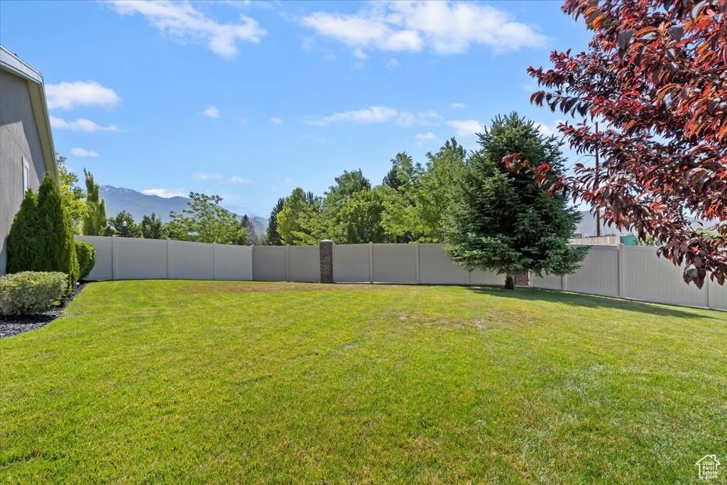 Fenced backyard featuring a mountain view