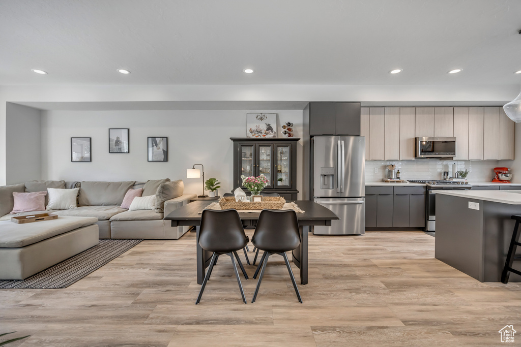 Dining room with light wood-style floors and recessed lighting