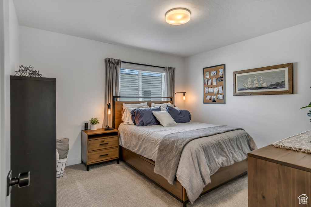 Bedroom with light carpet and baseboards