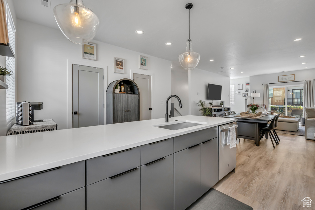 Kitchen with gray cabinets, dishwasher, open floor plan, recessed lighting, and light wood-type flooring