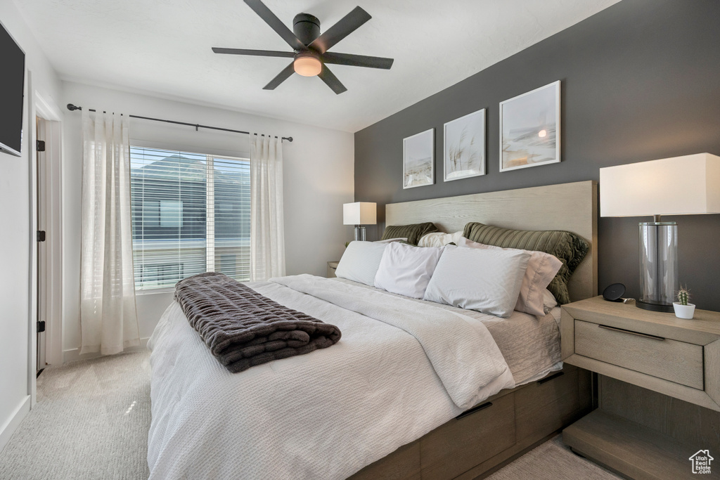 Bedroom with light colored carpet and ceiling fan
