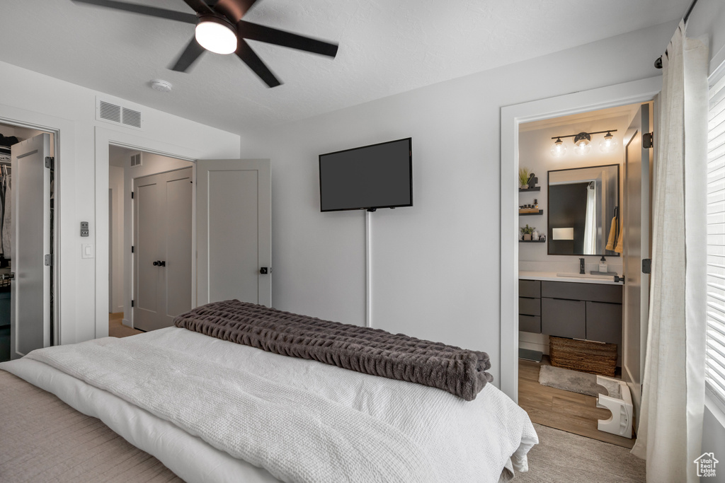 Bedroom featuring connected bathroom and a ceiling fan