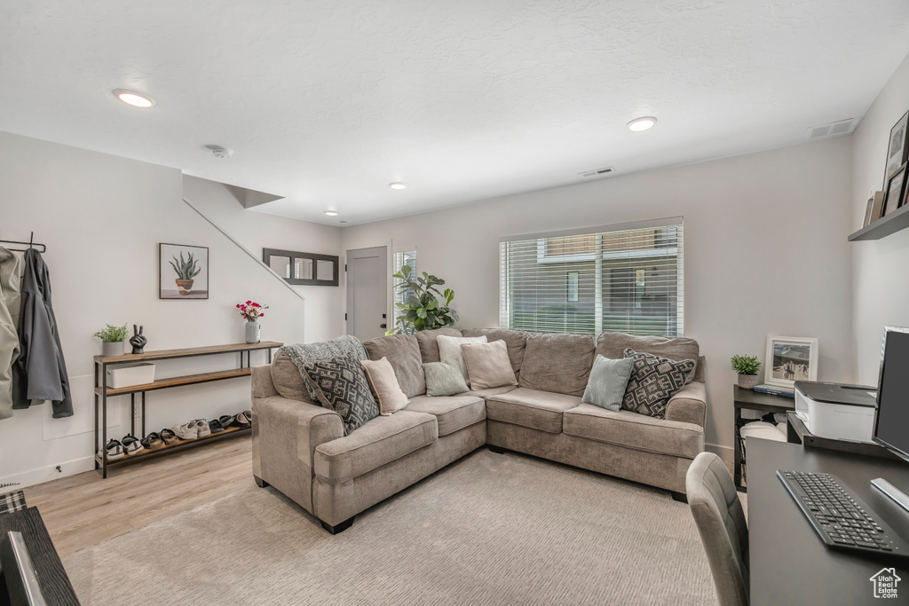 Living room featuring light wood-style flooring and recessed lighting