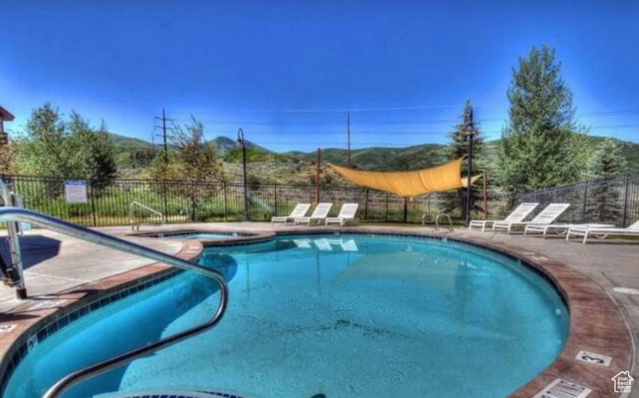 Community pool featuring a community hot tub and a patio