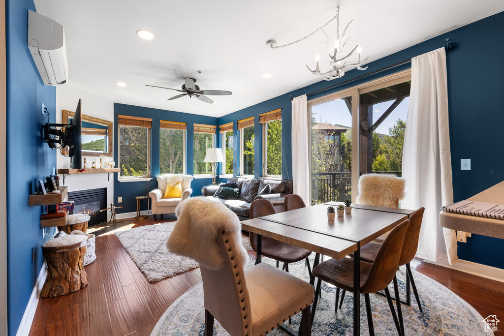 Dining area with a wall mounted air conditioner, baseboards, healthy amount of natural light, a glass covered fireplace, and recessed lighting