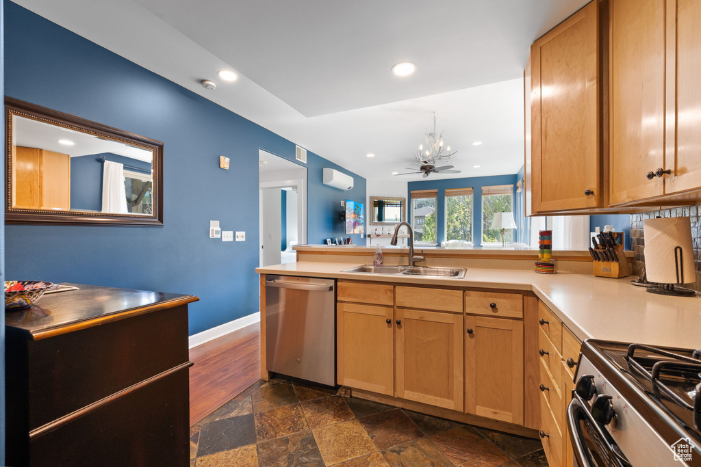 Kitchen with appliances with stainless steel finishes, a sink, recessed lighting, a peninsula, and light countertops