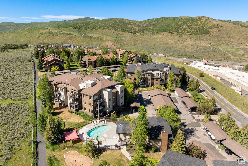 Aerial view of residential area featuring a pool and a mountainous background