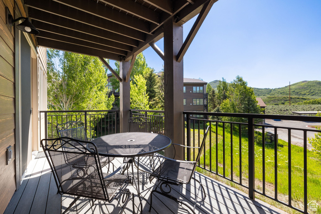 Balcony featuring outdoor dining area and a mountain view