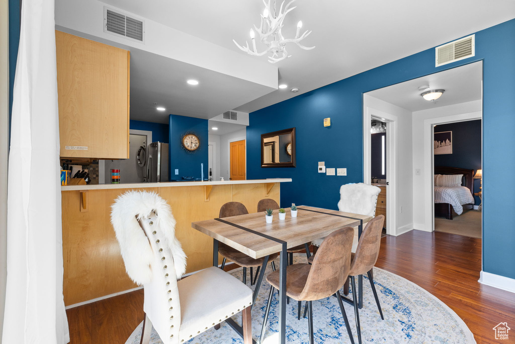 Dining area featuring wood finished floors, a chandelier, baseboards, and recessed lighting