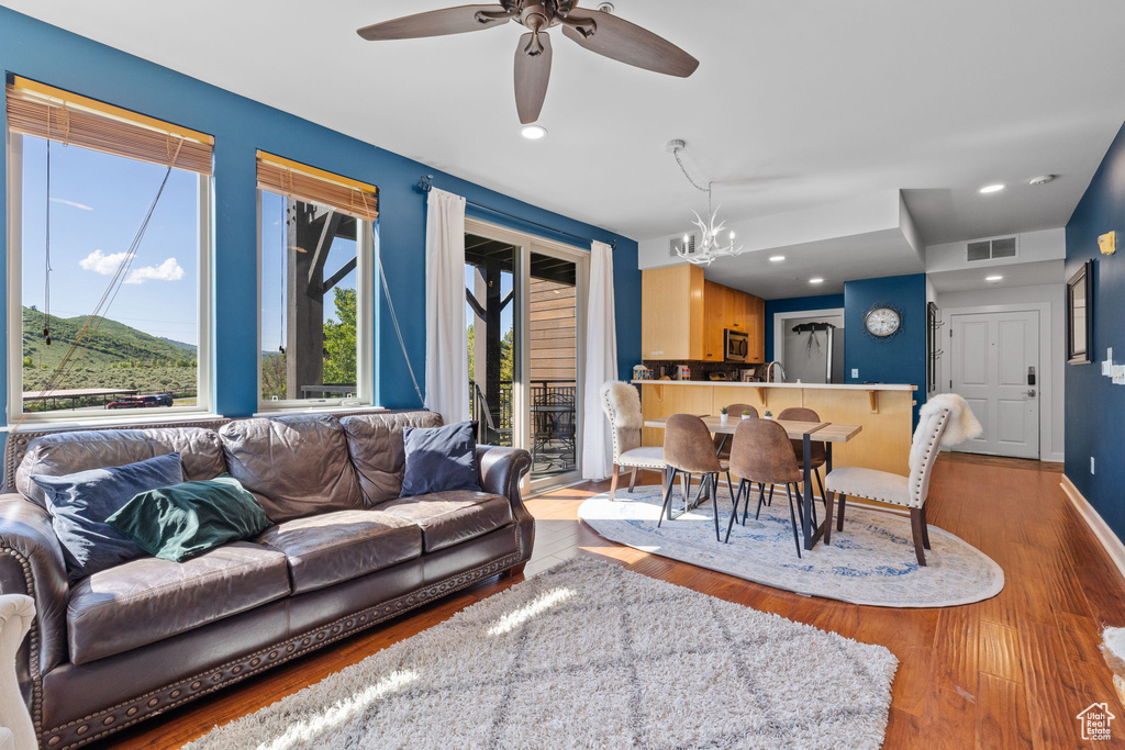 Living area featuring wood finished floors, a chandelier, a ceiling fan, recessed lighting, and baseboards
