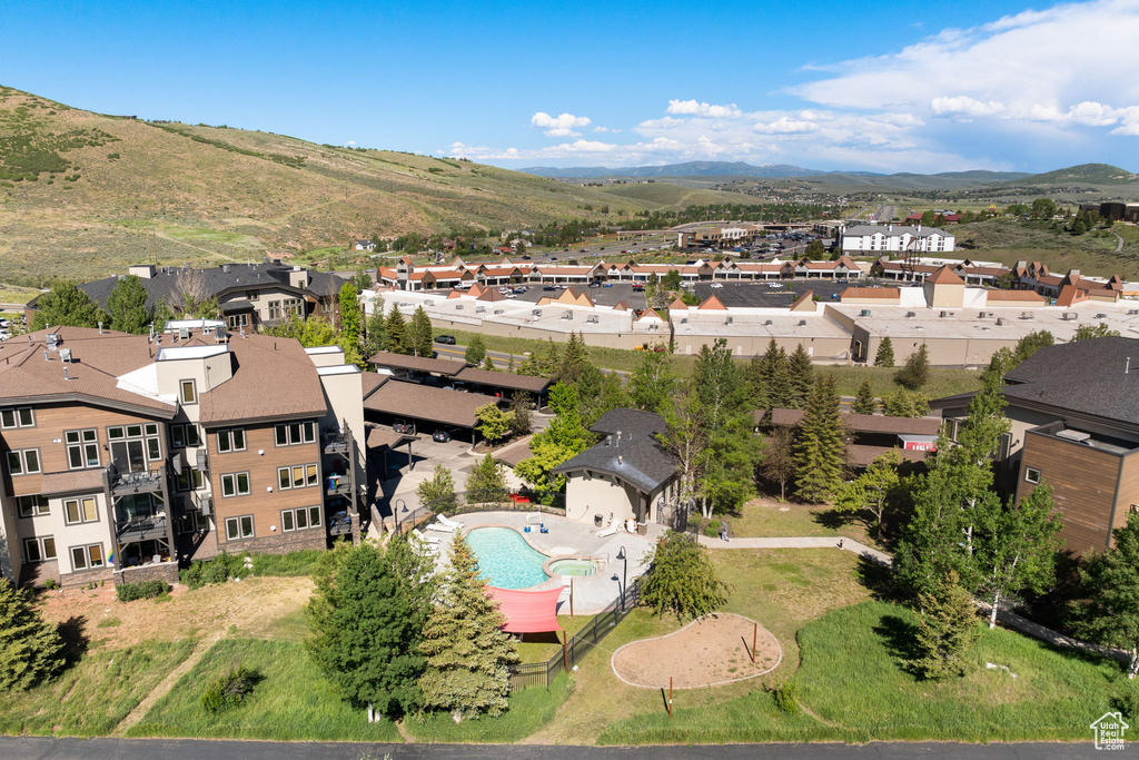 Aerial perspective of suburban area featuring a mountainous background and a pool area