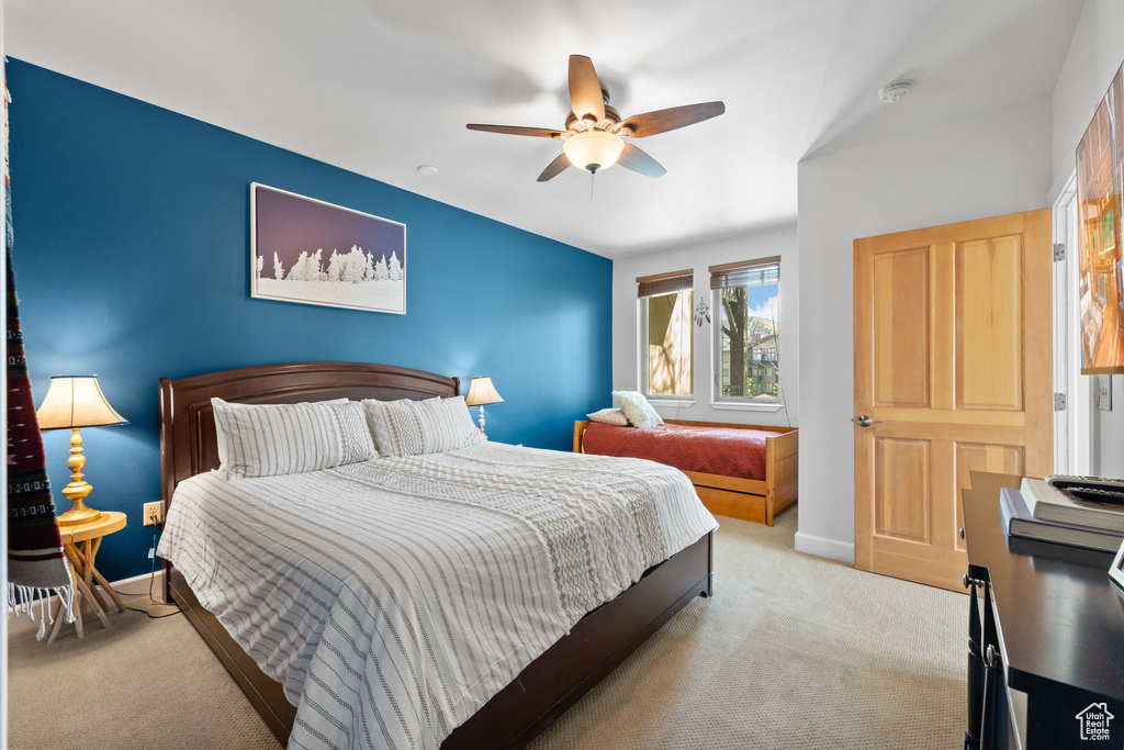 Carpeted bedroom with baseboards and a ceiling fan