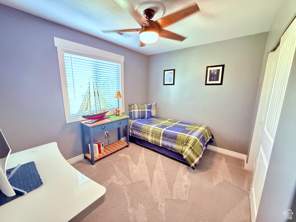 Bedroom with carpet, a closet, and a ceiling fan