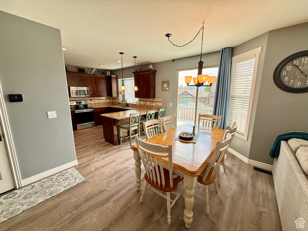 Dining area featuring light wood finished floors, recessed lighting, and a chandelier