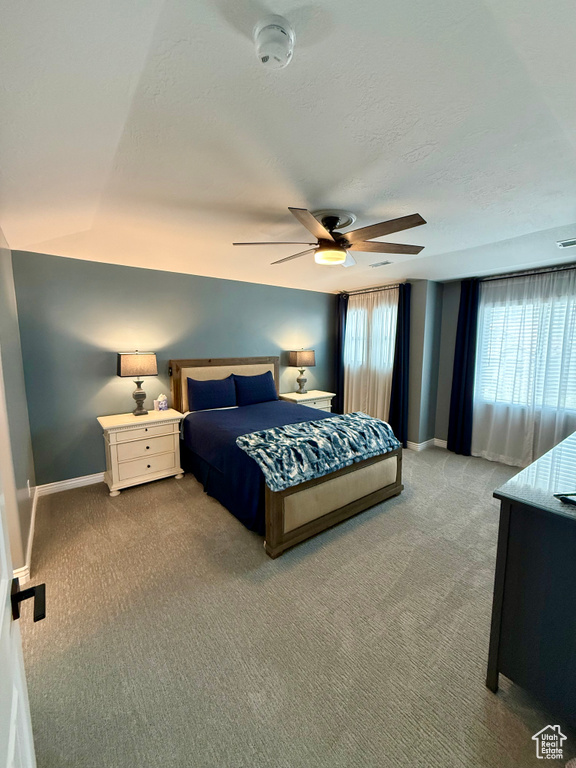 Carpeted bedroom with baseboards and ceiling fan