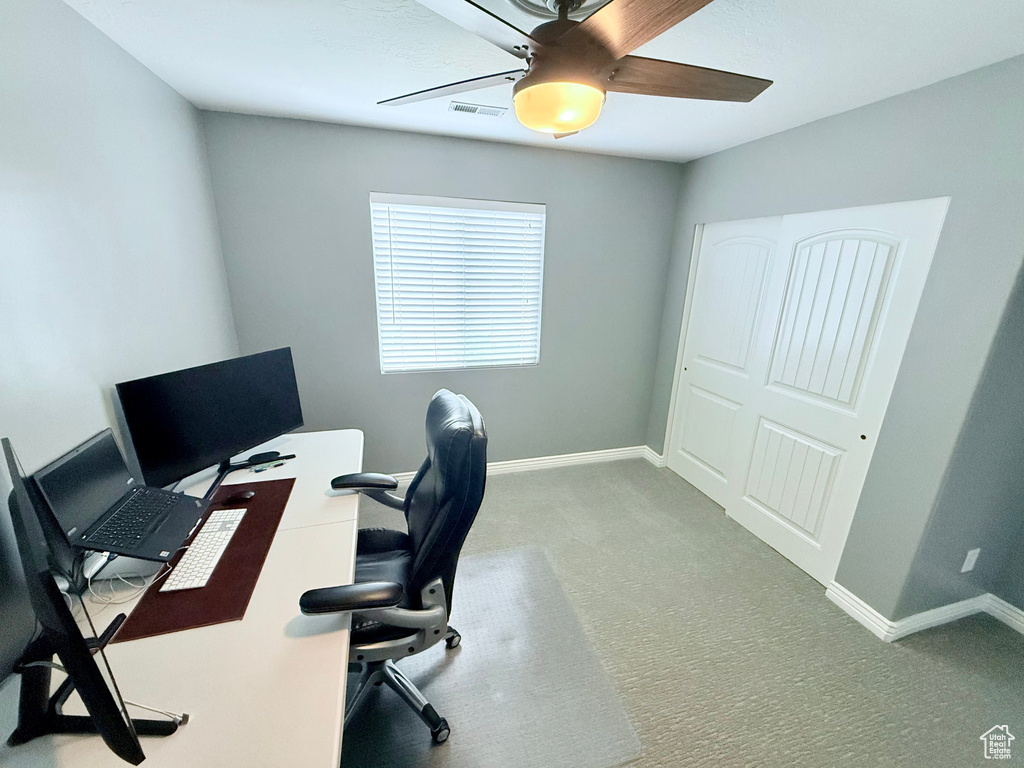 Office space with a ceiling fan and carpet