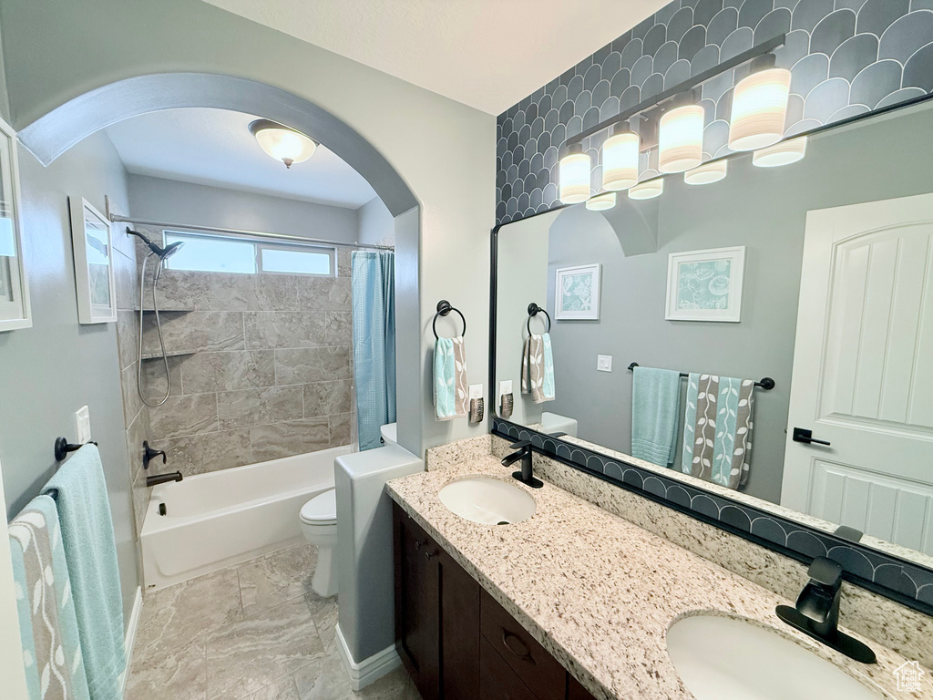 Full bathroom with double vanity and shower / bath combo